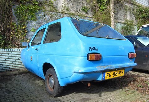 Light-blue hatchback from the rear quarter, Robin script on the tail, parked on brick paving. Opens a larger view