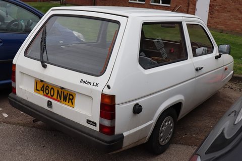 White hatchback from the rear quarter, Robin LX script beside the yellow number plate. Opens a larger view