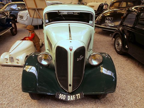 The front of a pale green car with a tall dark split grille and round headlamps on the wings. Opens a larger view
