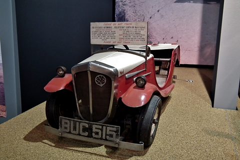 Front of a tiny open car: tall chrome radiator cowl with a round badge, two small lamps and plate BUC 515. Opens a larger view