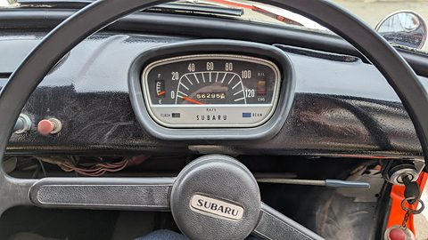Oval speedometer reading to 120 km/h in a black dashboard behind a black steering wheel with a SUBARU horn button. Opens a larger view