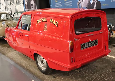 Red van from the rear quarter, gold Royal Mail script and crown on its side. Opens a larger view