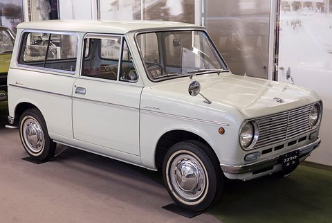 White small two-door van with a horizontal-bar grille, round headlamps, fender mirrors and white-wall tyres. Opens a larger view