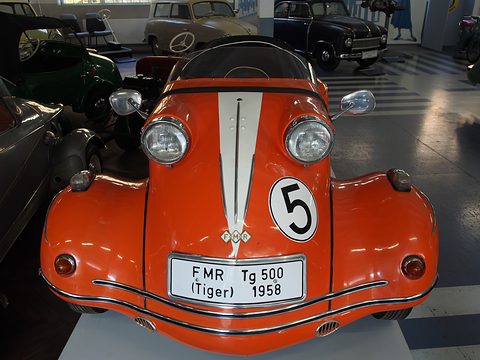 Front of an orange car with a white bonnet stripe, number 5 and twin headlamps on its wings. Opens a larger view