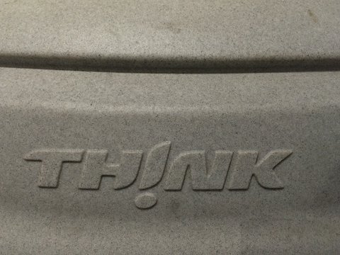 Close view of grey textured plastic with the raised word TH!NK moulded in italic capitals. Opens a larger view