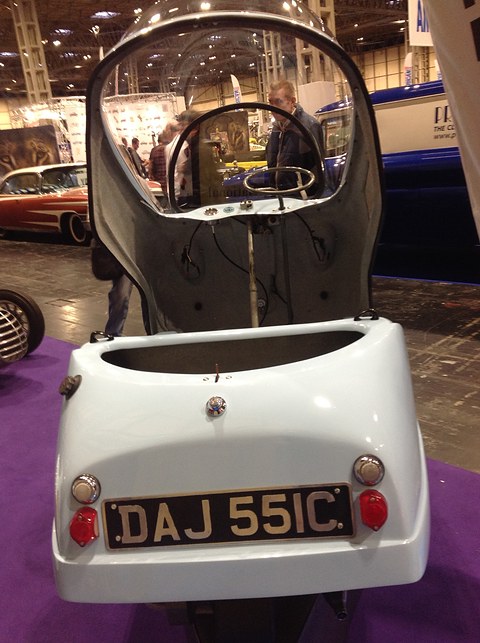 Pale blue bubble car from behind with its whole clear canopy raised forward. Opens a larger view