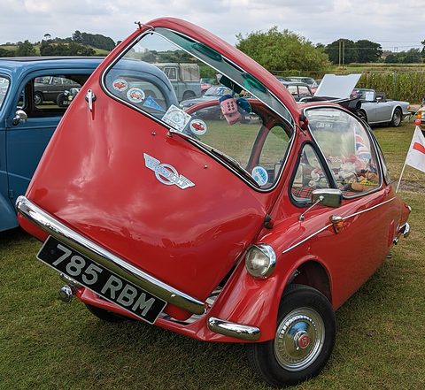 Red bubble car seen from the front, the whole nose opened as a door on its hinge. Opens a larger view