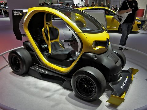 Yellow and black open racer with slick tyres and a front splitter on a grey turntable.