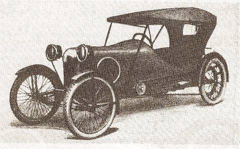A small dark open car with wire wheels, round headlamps and a tall fabric hood, seen from the front quarter.
