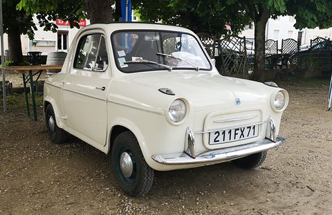 Cream small car with round headlamps and plate 211 FX 71, parked on gravel under chestnut trees. Opens a larger view