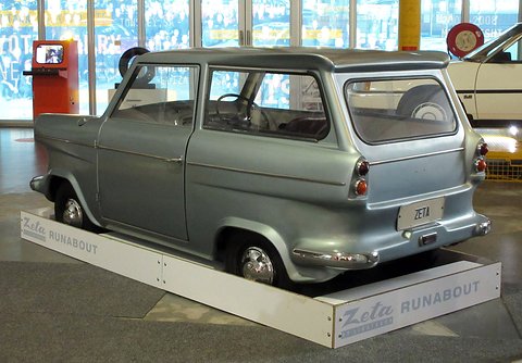 Grey-blue estate-shaped car seen from the rear left on a white plinth lettered Zeta Runabout.