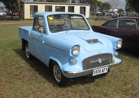 Pale blue small pickup with a mesh grille, a bonnet scoop and a South Australia number plate, parked on grass.